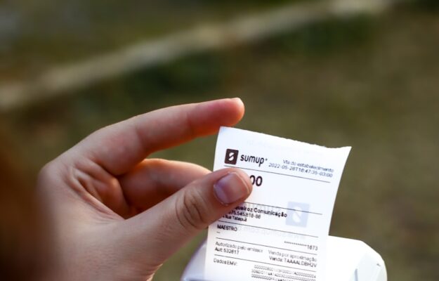 une personne tenant un téléphone portable et un reçu