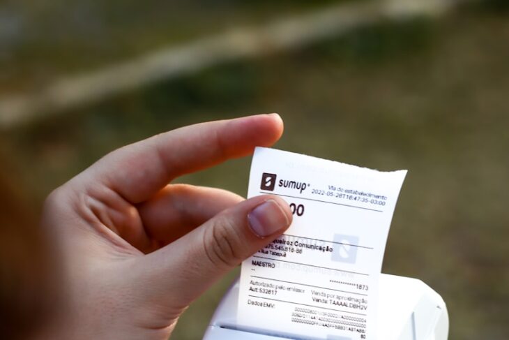 une personne tenant un téléphone portable et un reçu