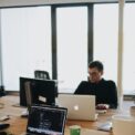 Un développeur Web travaillant sur du code dans un environnement de bureau moderne avec plusieurs appareils.