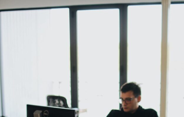 Un développeur Web travaillant sur du code dans un environnement de bureau moderne avec plusieurs appareils.
