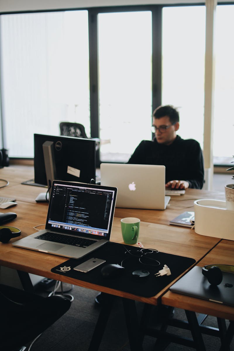 Un développeur Web travaillant sur du code dans un environnement de bureau moderne avec plusieurs appareils.