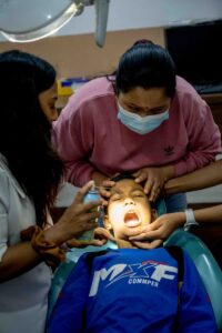 un groupe de personnes debout autour d'un homme sur une chaise de dentiste