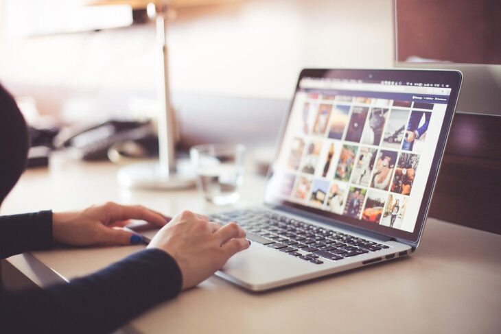 Une personne utilise un ordinateur portable affichant des images sur une table