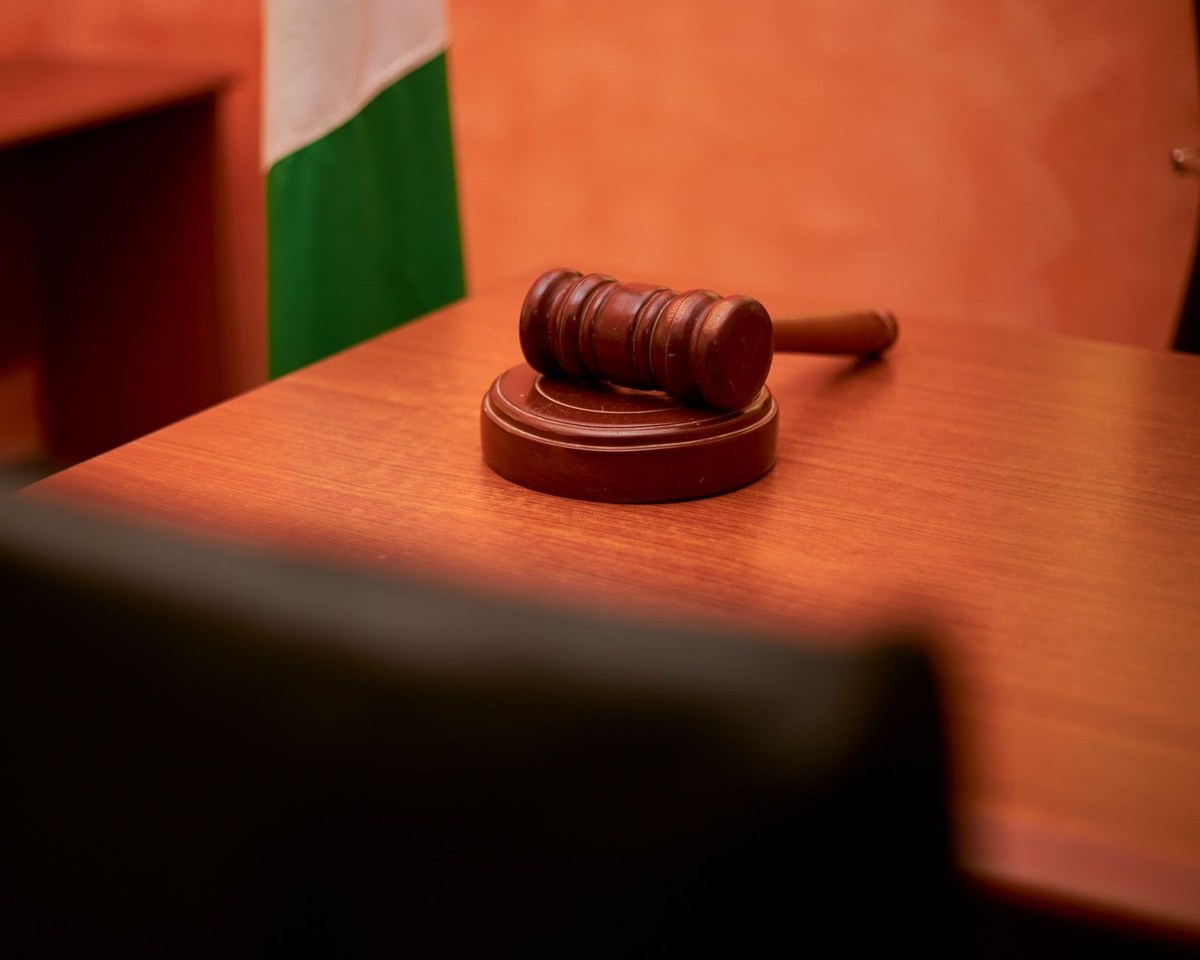 Gavel en bois posé sur une table, drapeau avec bandes vert et blanc à l'arrière-plan